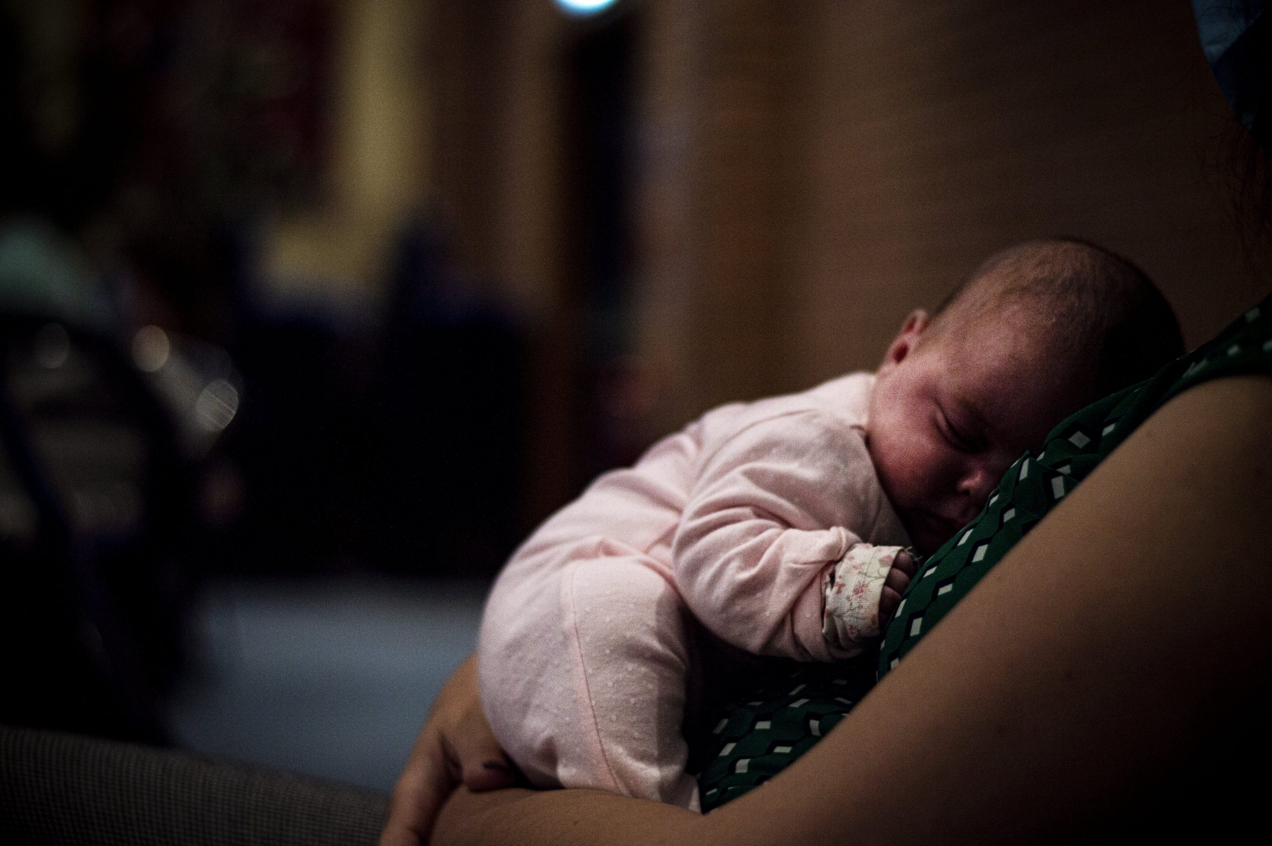 a baby asleep in mothers arms