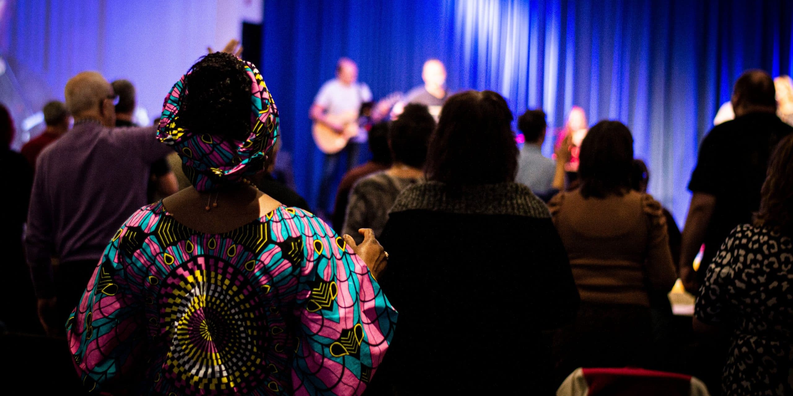 lady in African dress worshipping in church