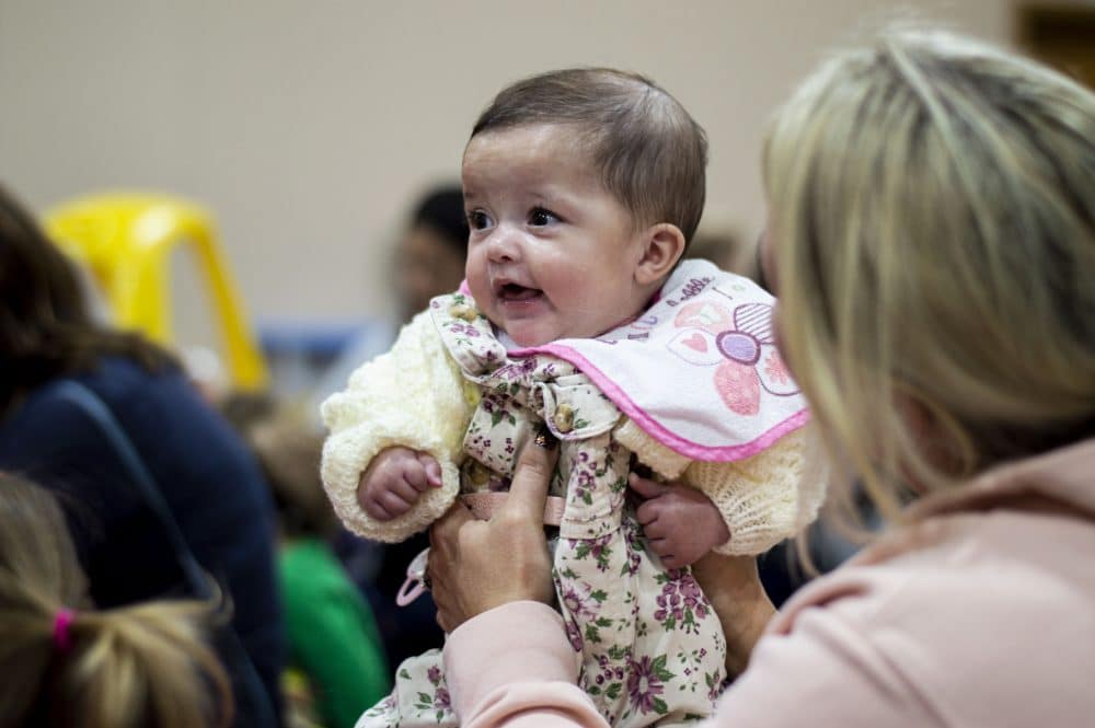 a baby being held by parent