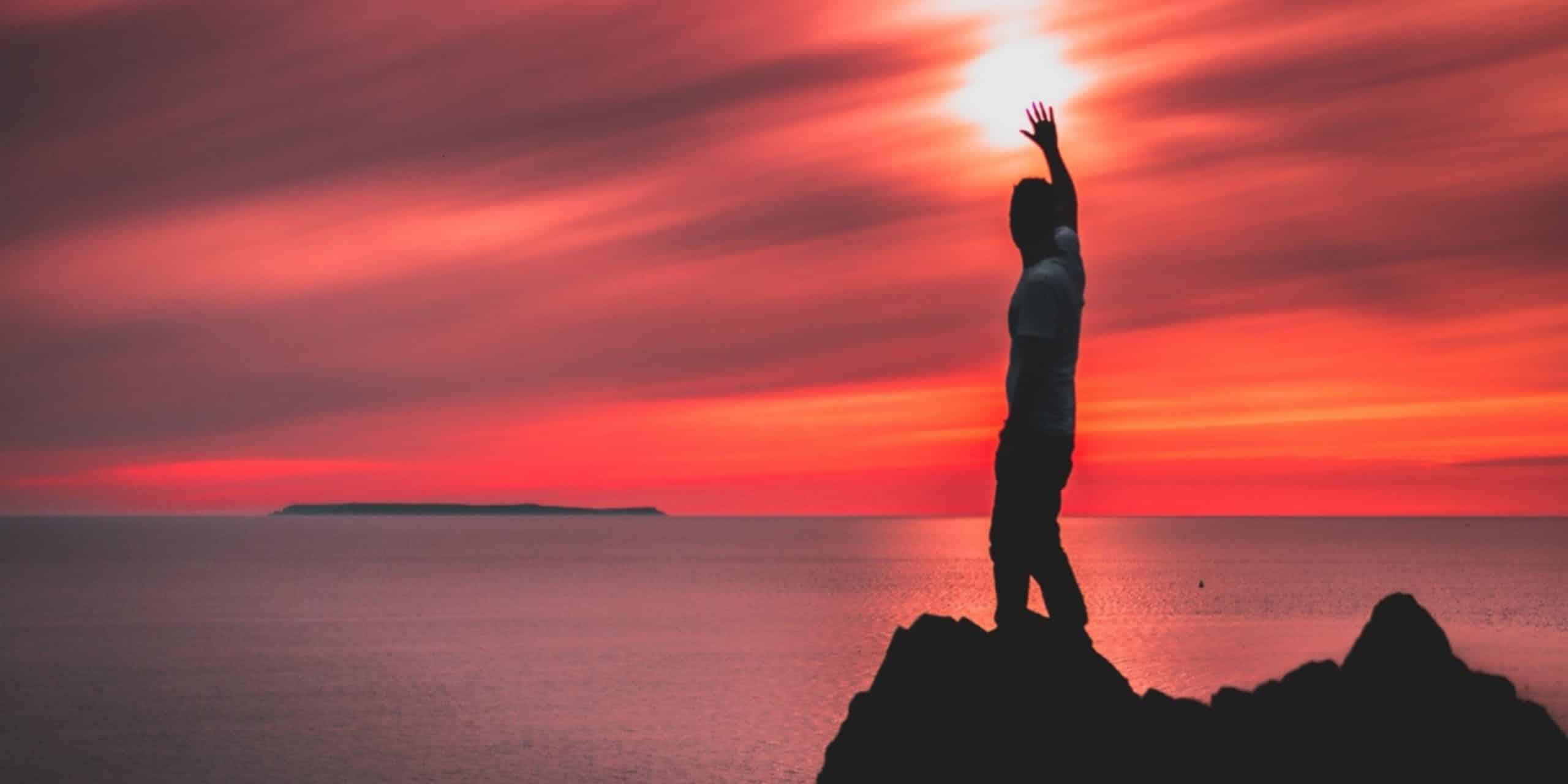 man reaching for the sun